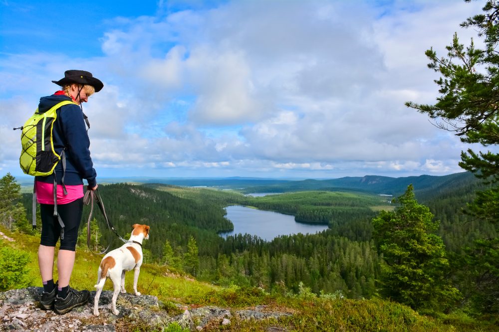 eine Frau mit ihrem Hund genießt die Schönheit der Natur in der Steiermark.